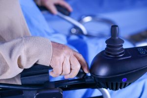 a person sitting in a black electric wheelchair